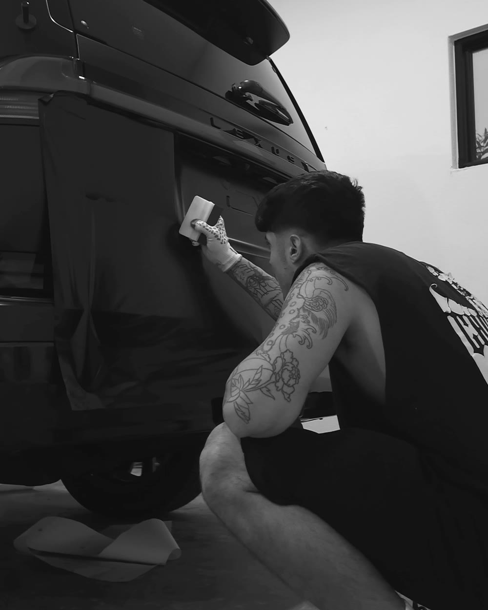 Installer working film across the tailgate